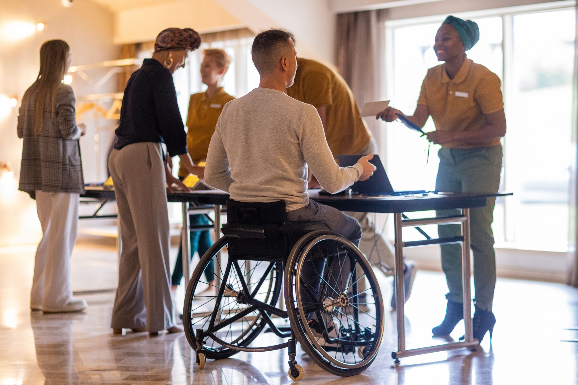 Disabled businessman registering for a business conference in a hotel's lobby